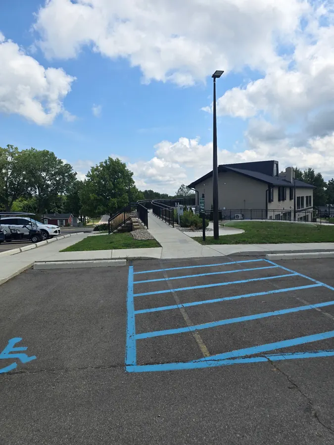 Concrete access ramp and sidewalk beside accessible parking at a commercial property