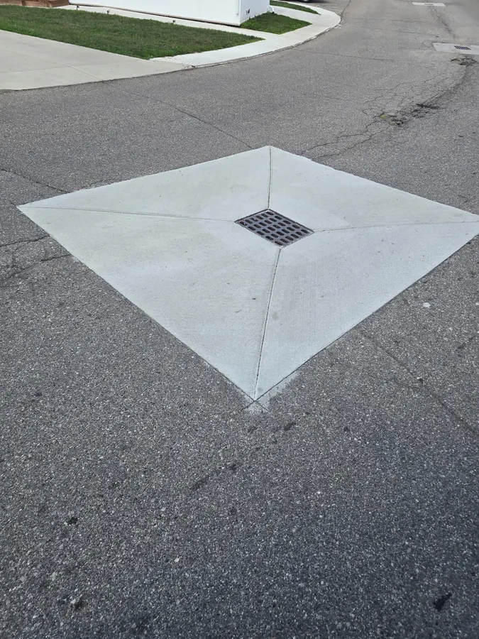 Concrete apron formed around a storm drain inlet