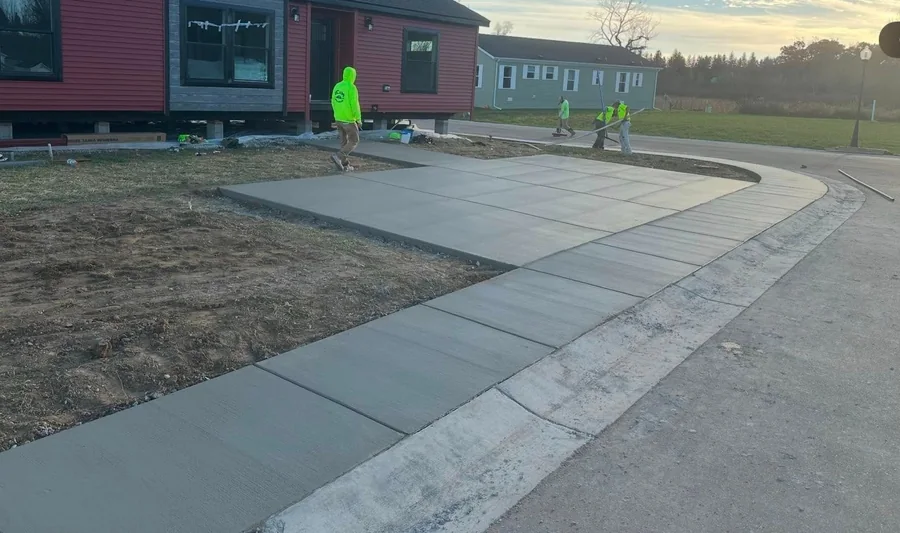 Finished curved concrete walkway and adjoining slab at a residential property