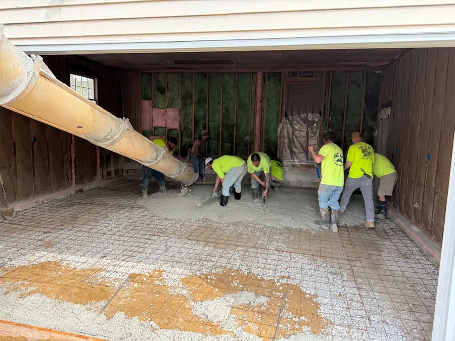 Concrete crew placing a new slab inside an existing structure