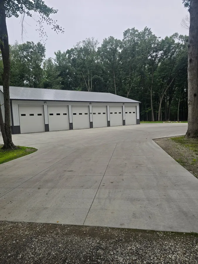 Large concrete driveway and apron in front of a multi-bay garage