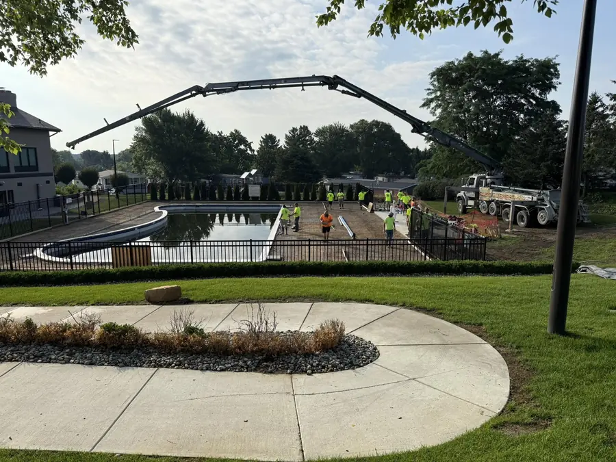 Concrete placement underway around a residential pool