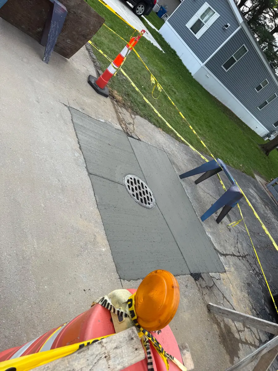 Sidewalk and drainage work underway beside a residential property