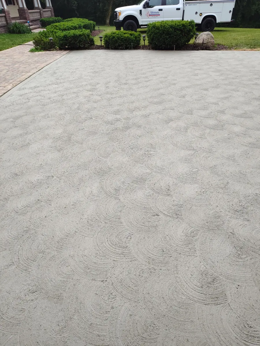 Close view of a decorative swirl finish on a new concrete driveway