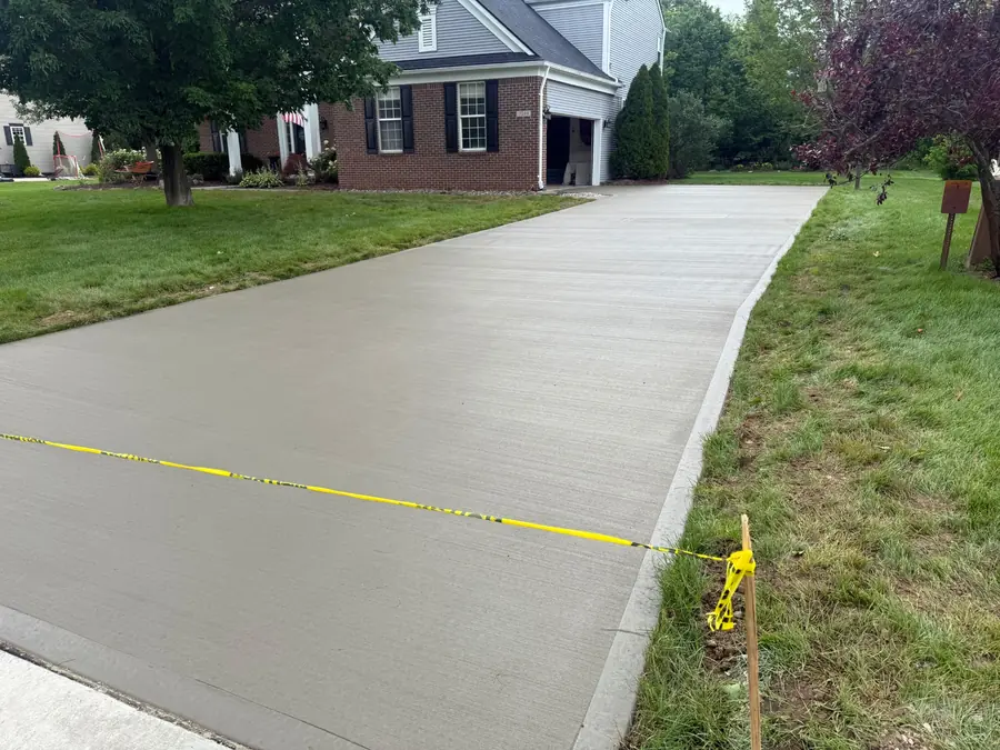 Wide new concrete driveway installed at a residential property